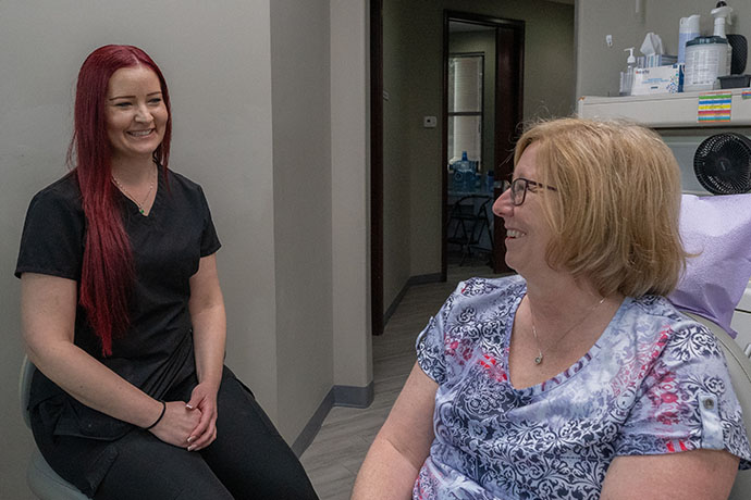 female patient smiles to a staff inside the dental office of Copperfield Dentistry